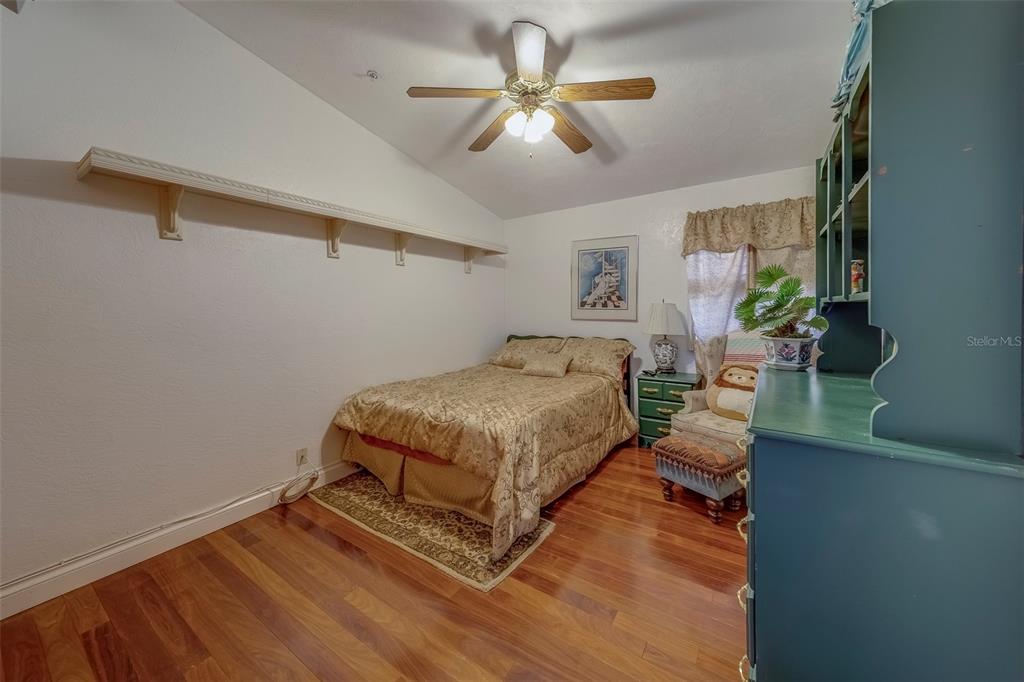 17606 Lee Avenue Redington Shores, FL 33708 - Photo 71 of 85 a bedroom with a bed couch chandelier and a window