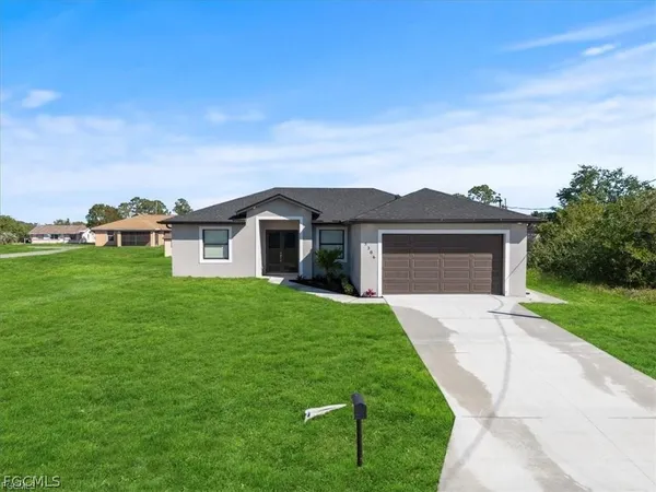 a front view of a house with a yard and garage