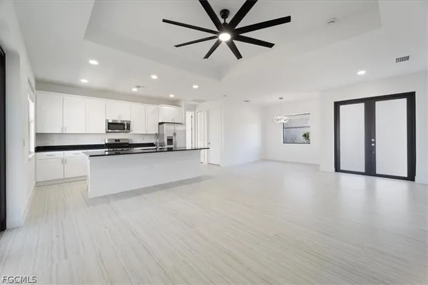 a view of kitchen with stainless steel appliances refrigerator stove microwave and cabinets