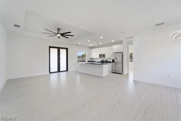 a view of an empty room with kitchen appliances and a window