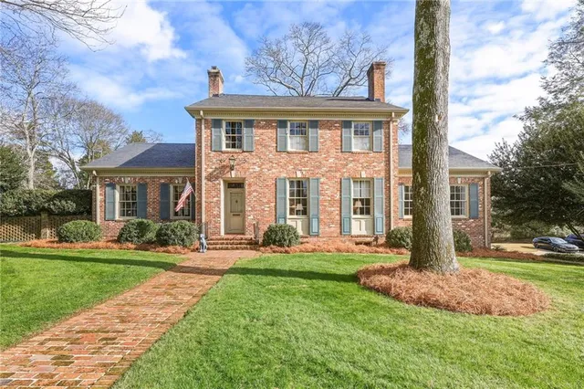 front view of a brick house with a yard