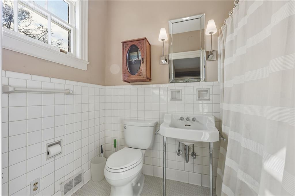 1606 Riverside Drive Gainesville, GA 30501 - Photo 32 of 55 a bathroom with a sink a toilet and mirror