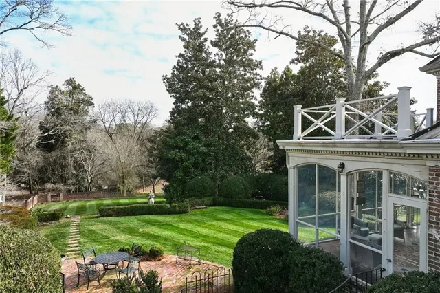 a view of a house with a big yard and large trees