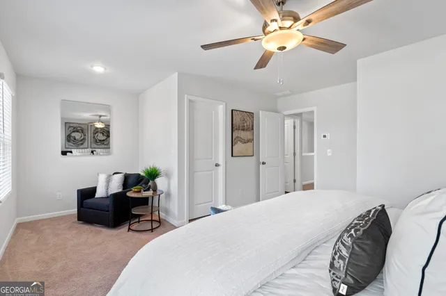 a spacious bedroom with a bed a desk and chair