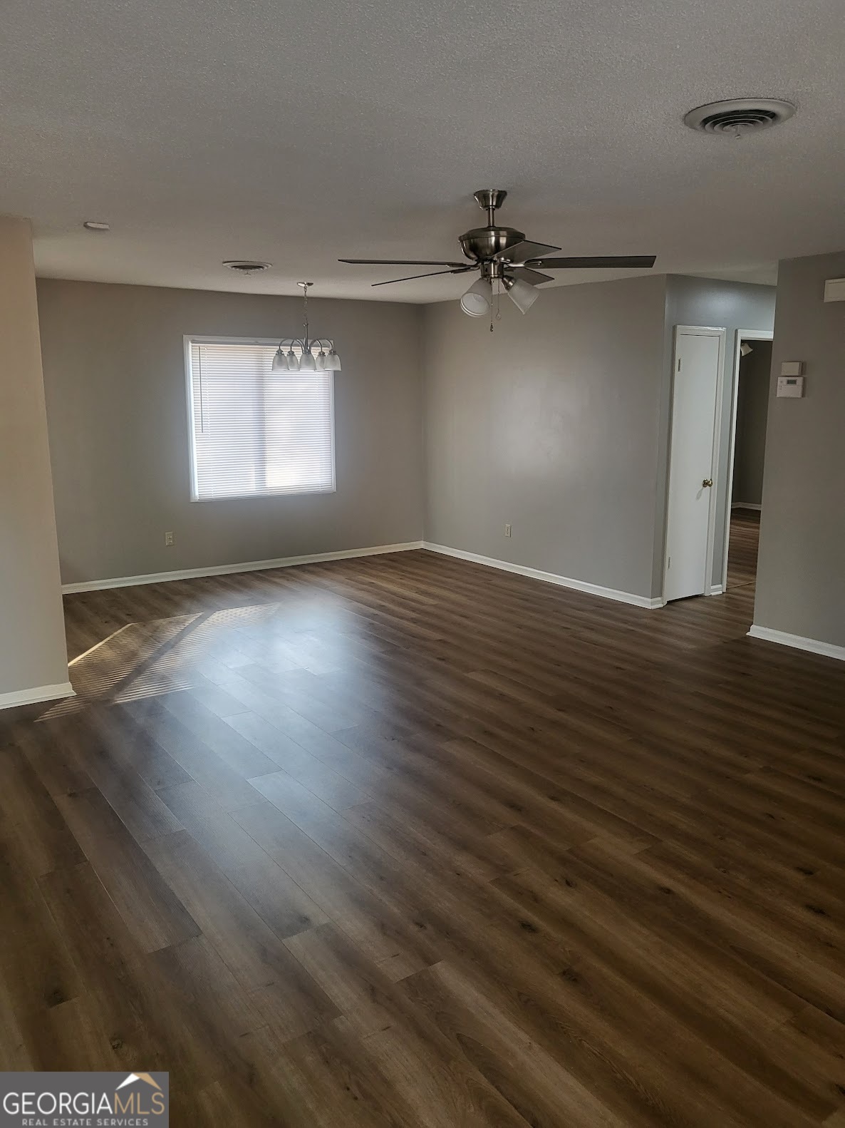 1207 Firestone Drive Albany, GA 31707 - Photo 3 of 15 an empty room with wooden floor cabinet and windows