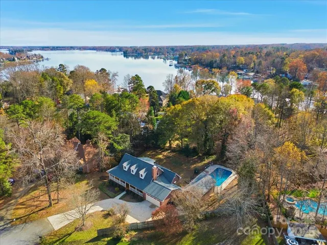 an aerial view of a house with a yard and lake view