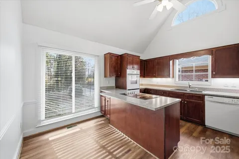 a kitchen with granite countertop a sink stove and cabinets