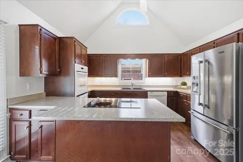 a kitchen with stainless steel appliances granite countertop a refrigerator stove and oven