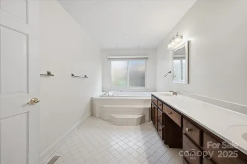 a bathroom with a tub sink and mirror