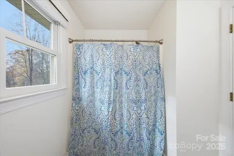 a bathroom with a shower curtain and a window