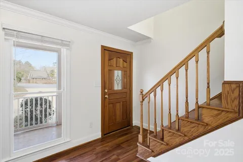a view of an entryway with wooden floor and door