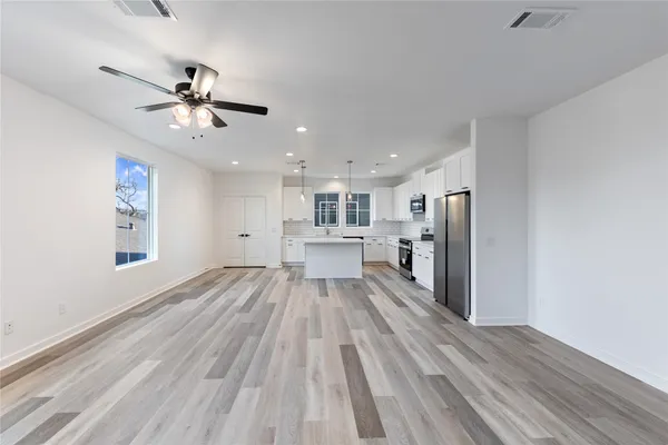 a kitchen with stainless steel appliances a stove a sink a microwave and cabinets