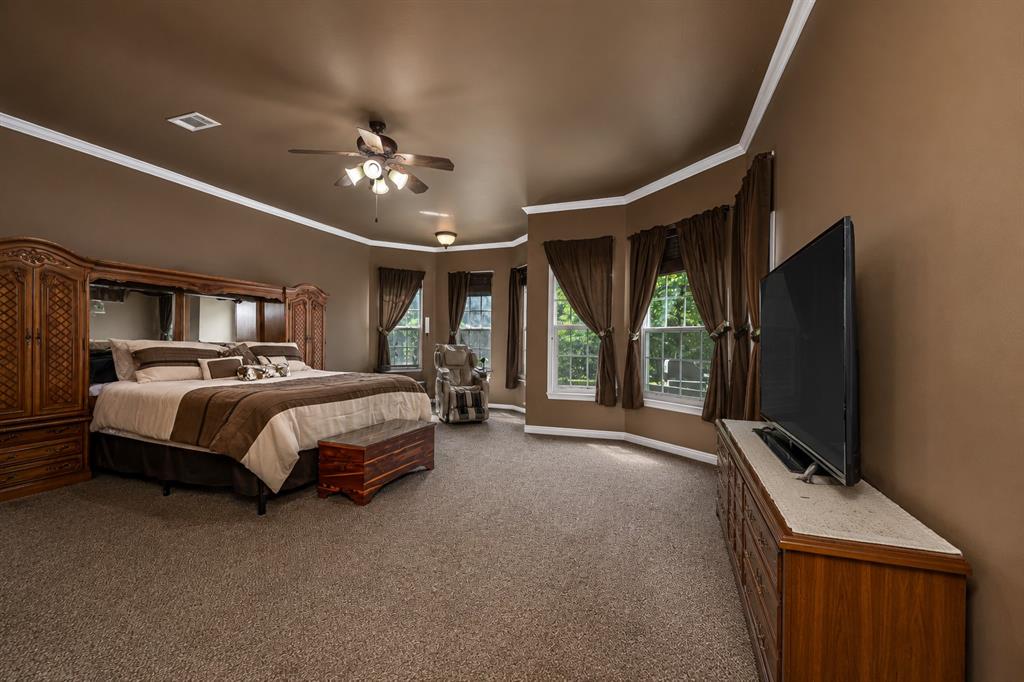 100 Manders Court Runaway Bay, TX 76426 - Photo 13 of 33 a spacious bedroom with a bed and a flat screen tv
