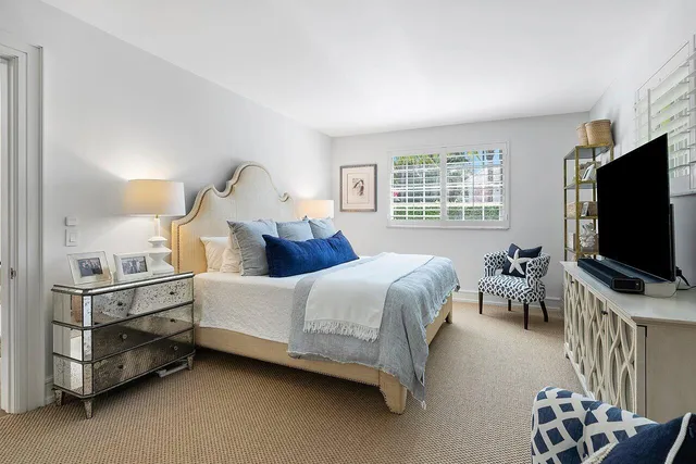 a spacious bedroom with a bed and a flat screen tv