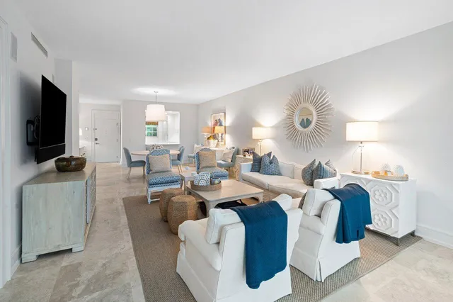 a living room with furniture a flat screen tv and large window