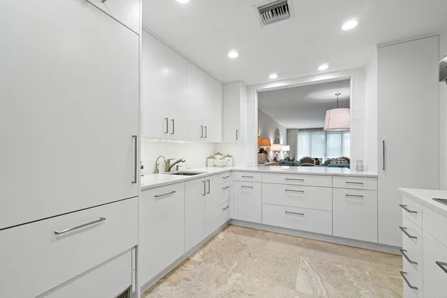 a large white kitchen with a sink and dishwasher