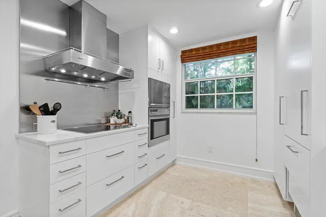 a kitchen with stainless steel appliances cabinets and a large window