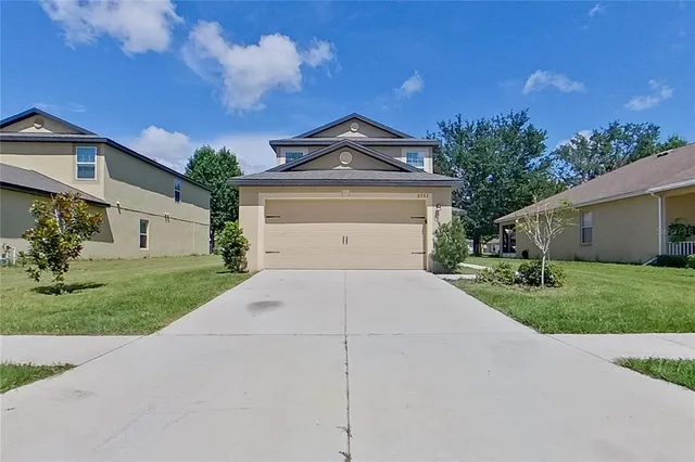 a front view of a house with a yard and garage