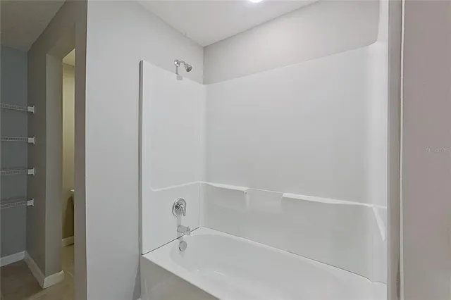 a white bath tub sitting next to a white sink and vanity