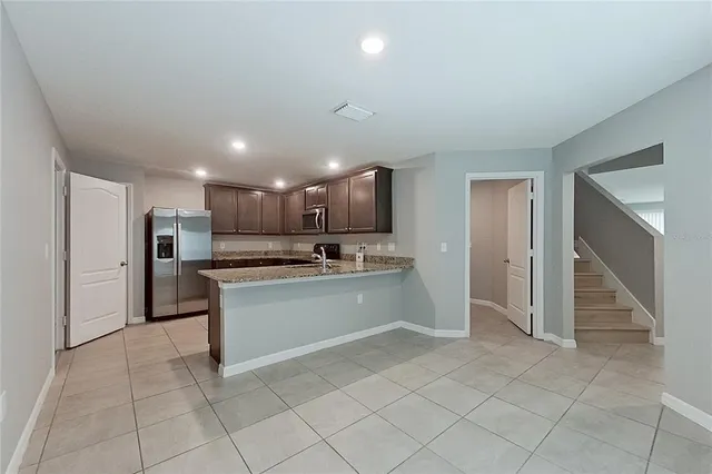 a large kitchen with a refrigerator and a stove top oven