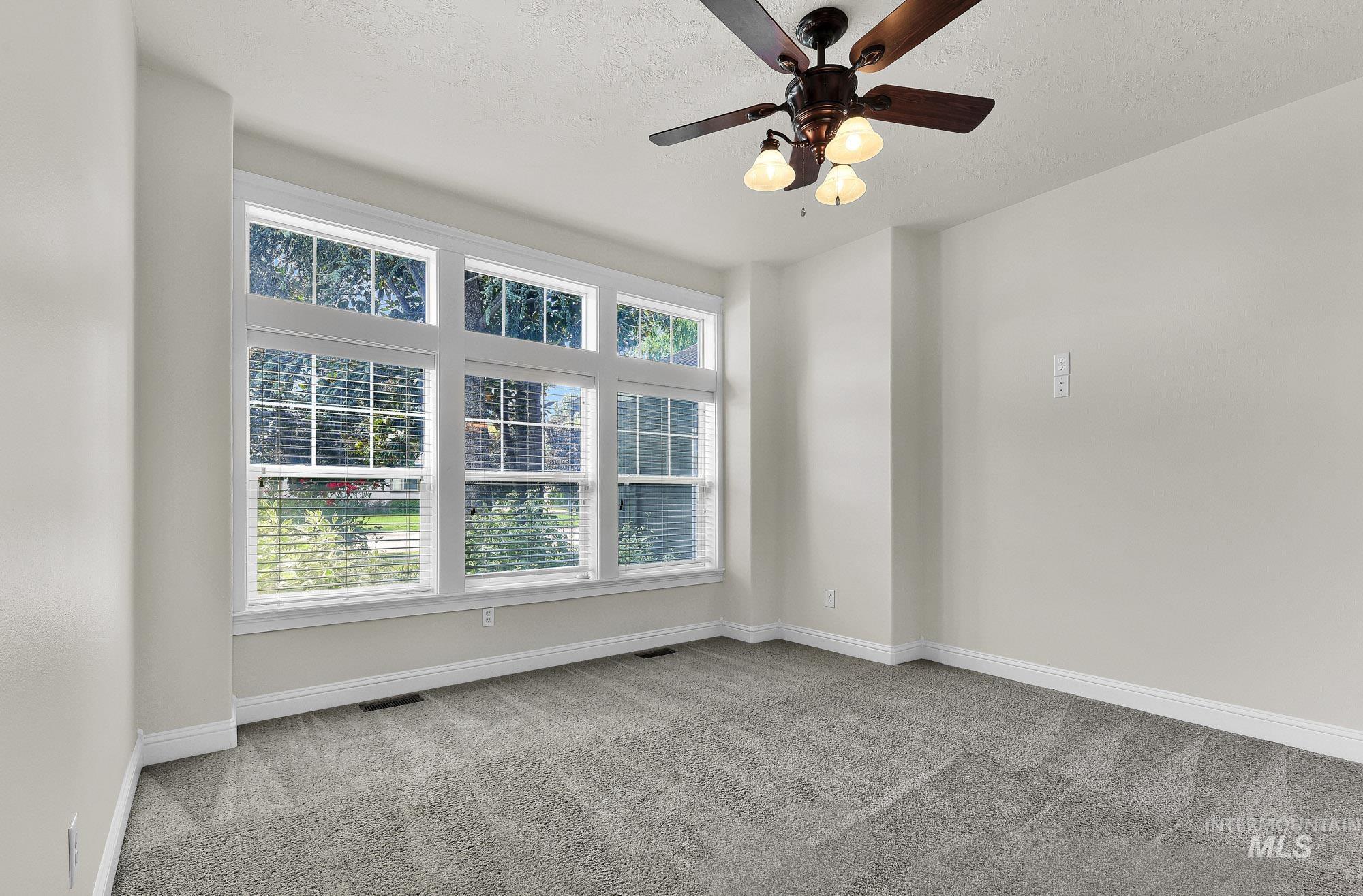 2172 West Cedar Grove Street Meridian, ID 83646 - Photo 5 of 49 Spacious room with plush gray carpeting, crisp white baseboards, and neutral wall tones