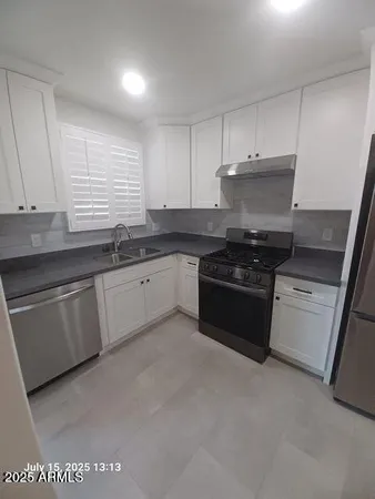a kitchen with granite countertop white cabinets and white appliances