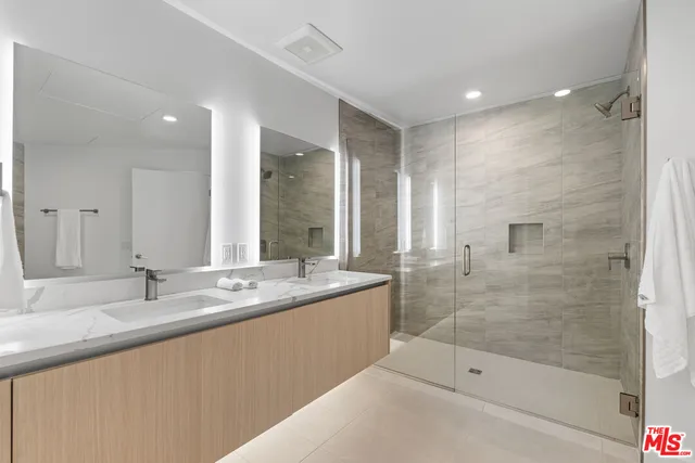 a bathroom with a granite countertop sink mirror and shower