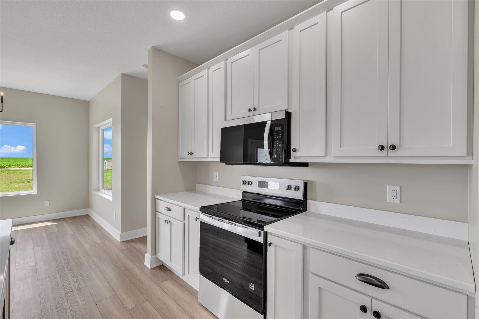 455 Rhonda Road New Liberty, IA 52765 - Photo 23 of 54 a kitchen with stainless steel appliances white cabinets and a stove top oven
