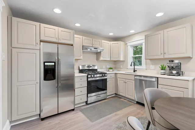 a kitchen with stainless steel appliances white cabinets and a refrigerator