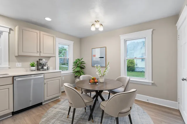 a kitchen with a dining table chairs and window