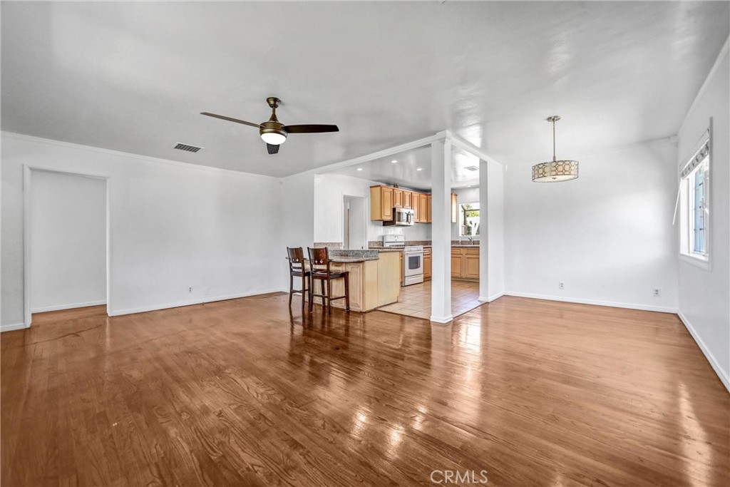 6225 Langdon Avenue Van Nuys, CA 91411 - Photo 4 of 15 a view of a livingroom with a dinning area hardwood floor a ceiling fan and windows