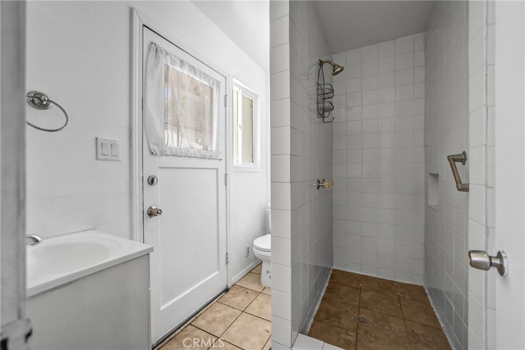 6225 Langdon Avenue Van Nuys, CA 91411 - Photo 8 of 15 a bathroom with a granite countertop shower a toilet and a sink