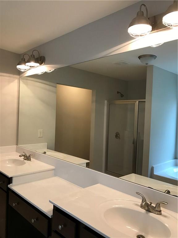 5934 Watersdown Way Flowery Branch, GA 30542 - Photo 16 of 28 a bathroom with a sink and a mirror