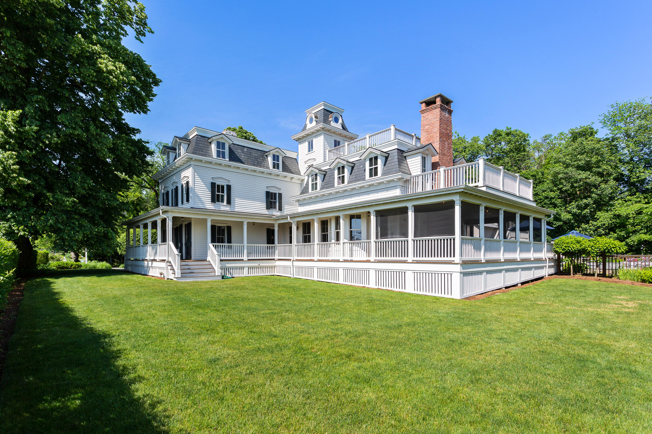 136 Pear Tree Point Road Darien, CT 06820 - Photo 4 of 56 a front view of a house with a yard table and chairs
