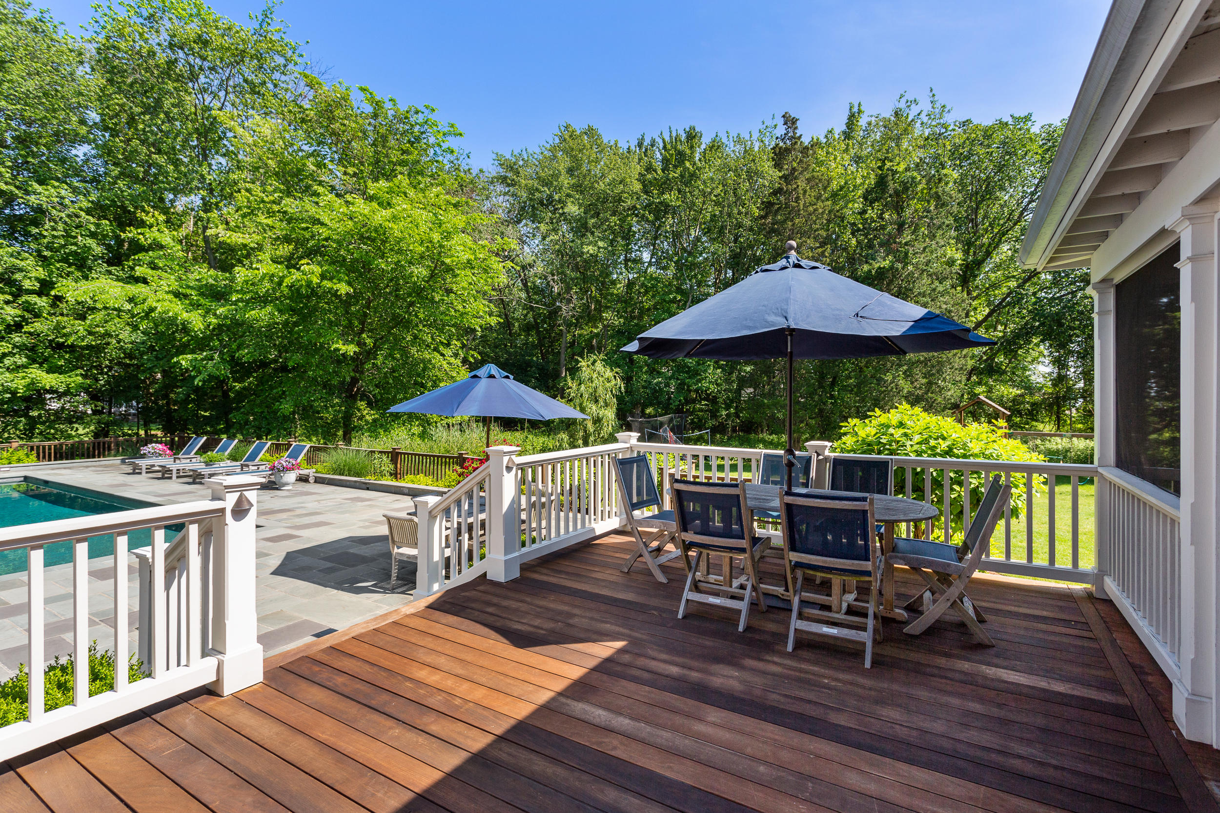 136 Pear Tree Point Road Darien, CT 06820 - Photo 50 of 56 a view of a roof deck with table and chairs under an umbrella with wooden floor