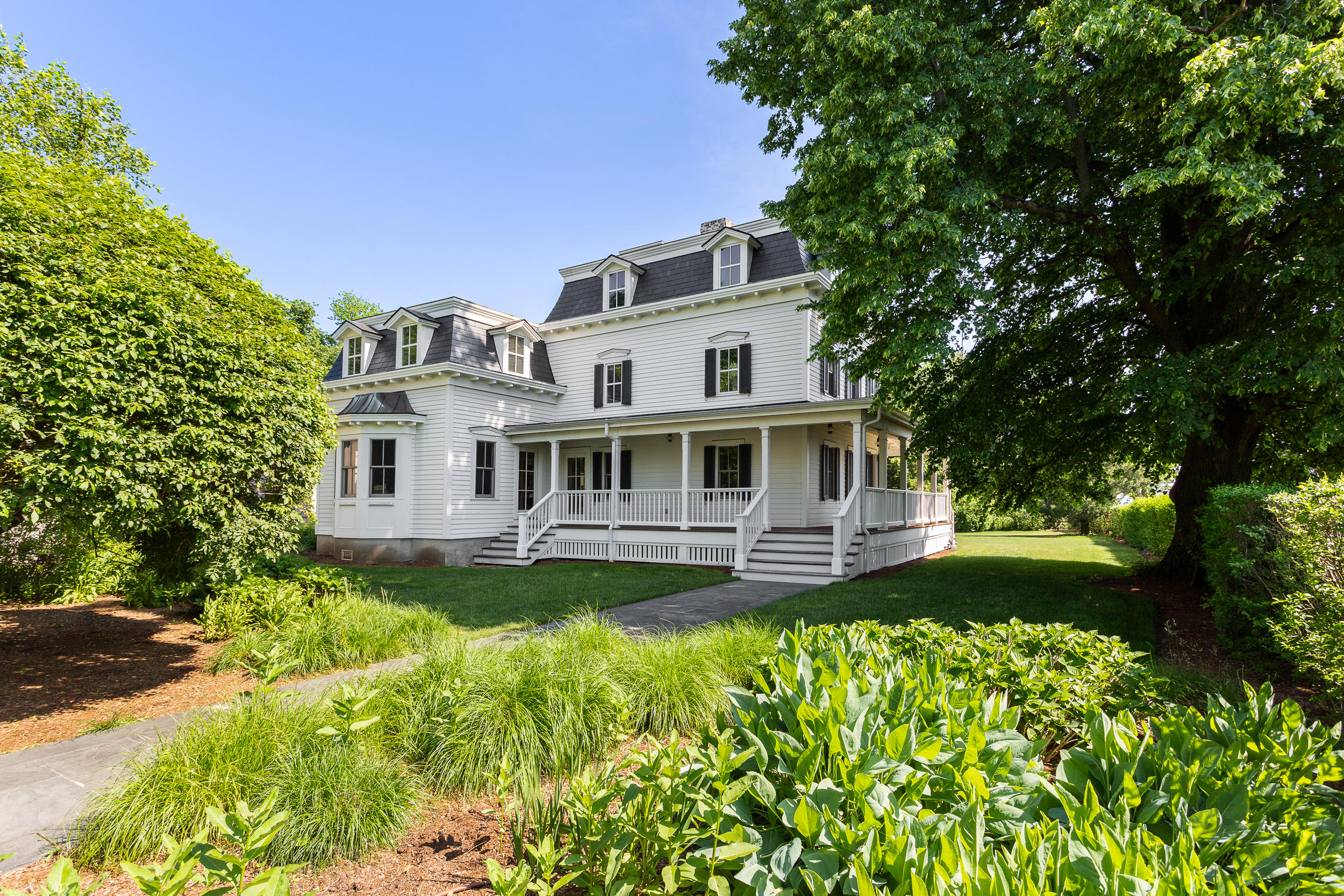 136 Pear Tree Point Road Darien, CT 06820 - Photo 5 of 56 a front view of a house with a yard table and chairs
