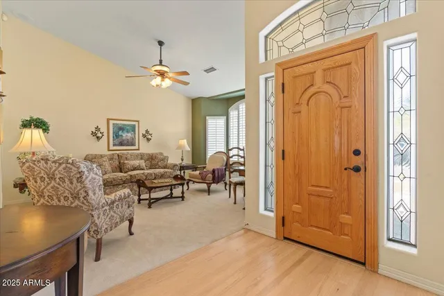 a dining room with wooden floor a chandelier a wooden table and chairs