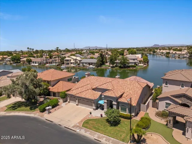 an aerial view of residential houses with outdoor space and ocean