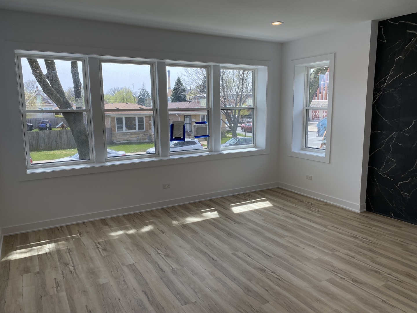 4352 West Augusta Boulevard, Unit 1 Chicago, IL 60651 - Photo 2 of 16 a view of an empty room with wooden floor and a window