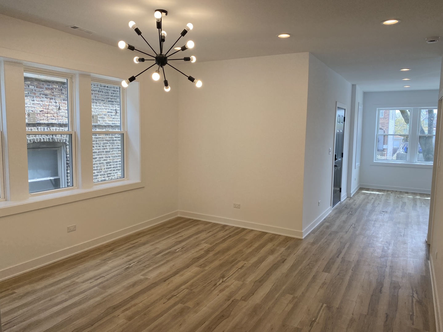 4352 West Augusta Boulevard, Unit 1 Chicago, IL 60651 - Photo 4 of 16 a view of an empty room with wooden floor and a window