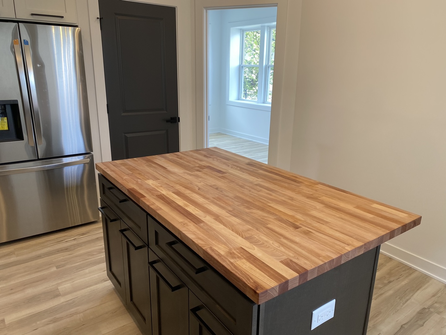 4352 West Augusta Boulevard, Unit 1 Chicago, IL 60651 - Photo 7 of 16 a kitchen with stainless steel appliances granite countertop a refrigerator and a wooden floor