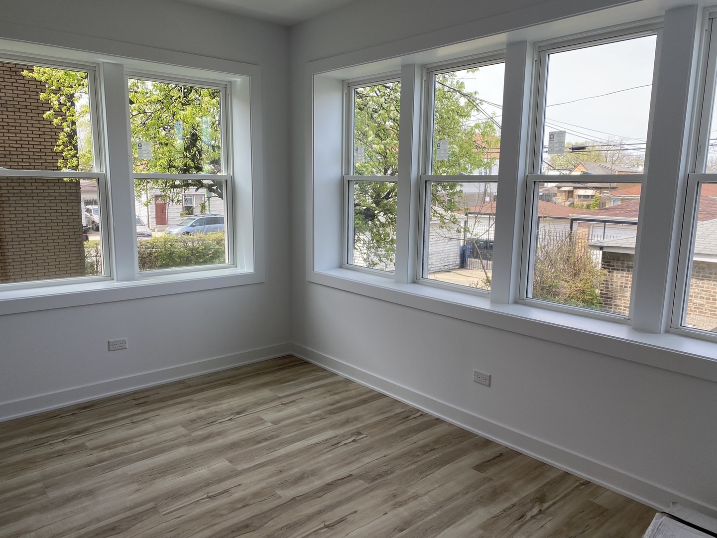 4352 West Augusta Boulevard, Unit 1 Chicago, IL 60651 - Photo 8 of 16 a view of an empty room with wooden floor and a window