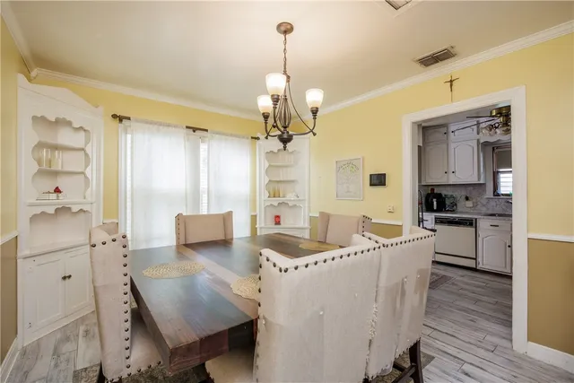 a living room with furniture a dining table and a chandelier
