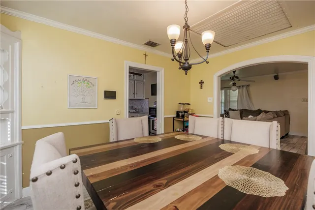 a spacious bedroom with a bed a chandelier and a couch
