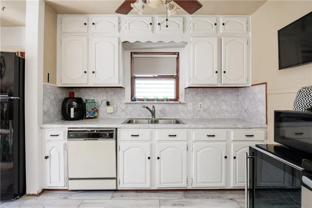 a kitchen with white cabinets and white appliances