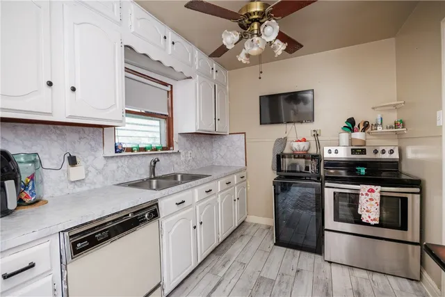 a kitchen with stainless steel appliances granite countertop a sink a stove and cabinets