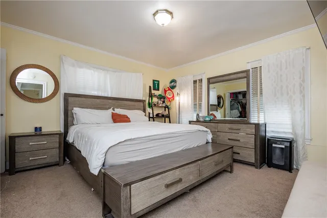a bedroom with a bed and a large mirror