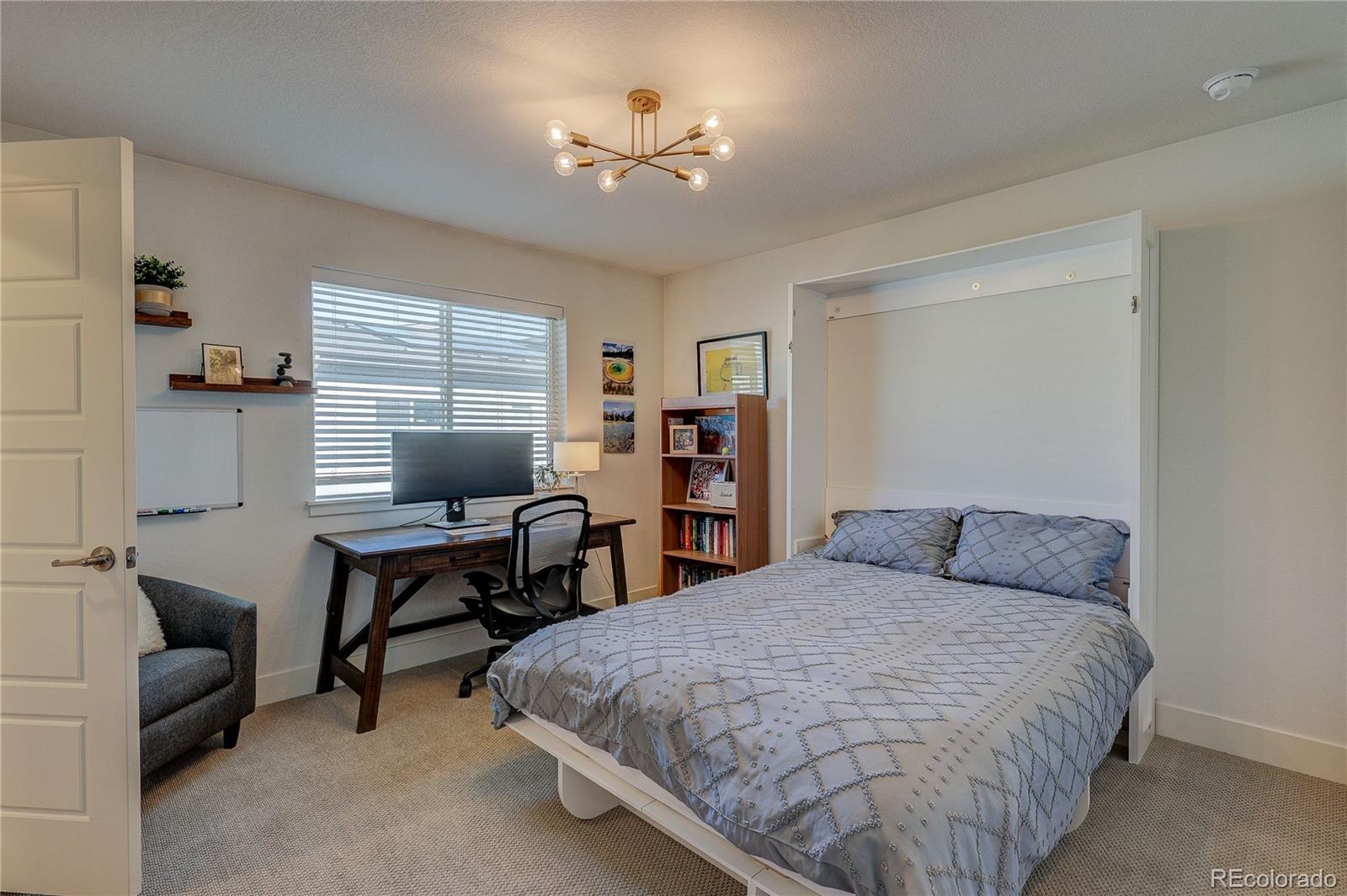 7825 West 42nd Avenue Wheat Ridge, CO 80033 - Photo 21 of 35 a bedroom with a bed and a chandelier