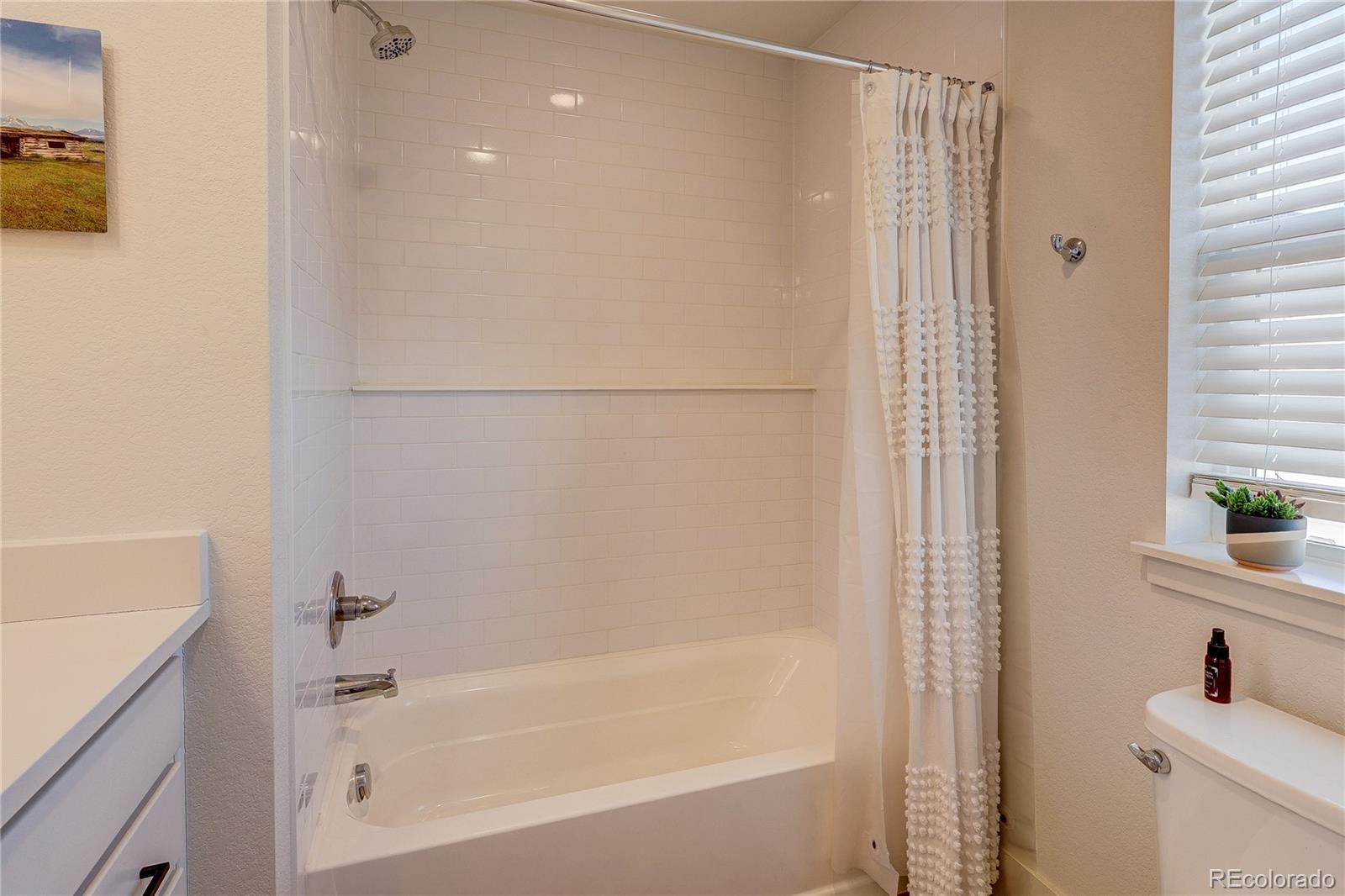 7825 West 42nd Avenue Wheat Ridge, CO 80033 - Photo 26 of 35 a bathroom with a bathtub and a shower