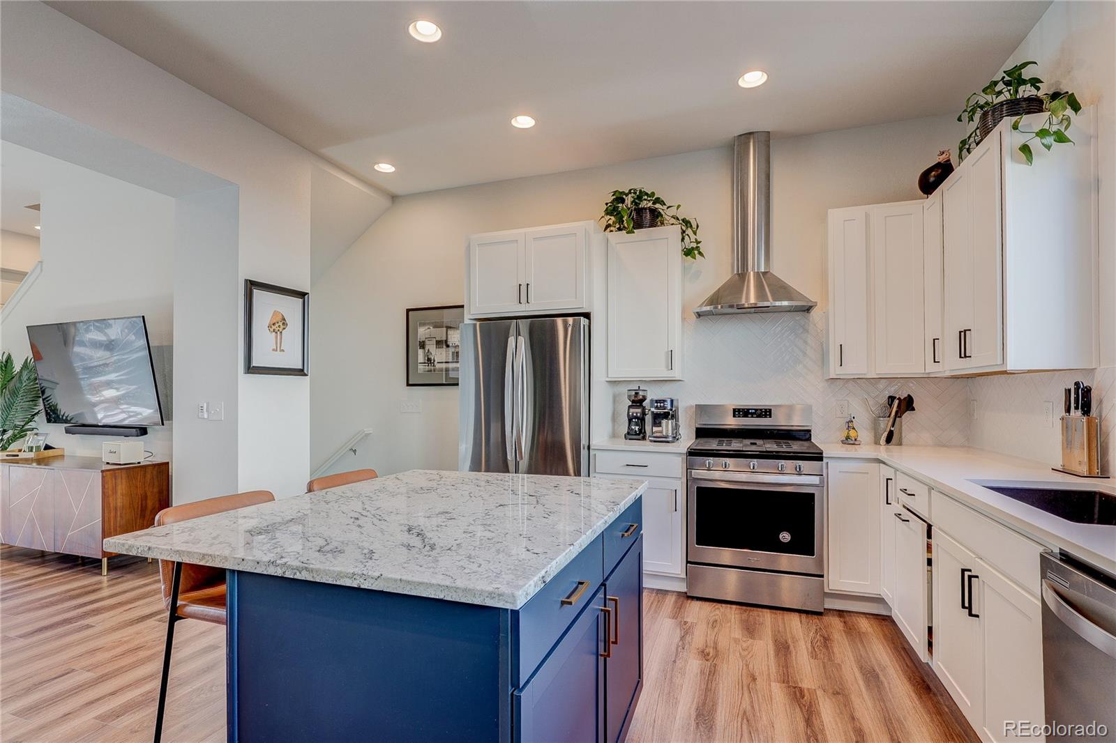 7825 West 42nd Avenue Wheat Ridge, CO 80033 - Photo 6 of 35 a kitchen with stainless steel appliances granite countertop a sink stove and refrigerator